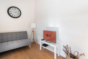 a living room with a couch and a clock on the wall at GuestReady - Oporto Old Town House 3 in Porto
