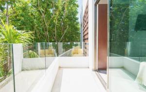 a glass door leading to a balcony with trees at Hotel Piedra del Caribe Puerto Morelos in Puerto Morelos