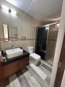 a bathroom with a sink and a toilet and a mirror at Hotel Piedra del Caribe Puerto Morelos in Puerto Morelos