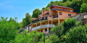 een gebouw aan de zijkant van een heuvel met bomen bij Lakeview Apartments Anđela in Virpazar