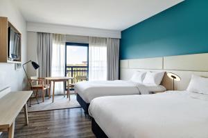 a hotel room with two beds and a table at Crowne Plaza Sydney Macquarie Park by IHG in Sydney