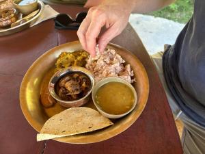 una persona que busca comida en un plato de comida en Olive Eco Village Hotel, en Pārtol 13 fotos más