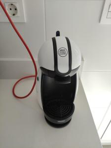 a black and white coffee maker with a red cord at Pequeña habitación con vistas dentro de nuestra vivienda in Irún