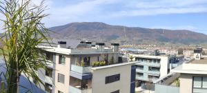 a view of a building with a mountain in the background at Pequeña habitación con vistas dentro de nuestra vivienda in Irún