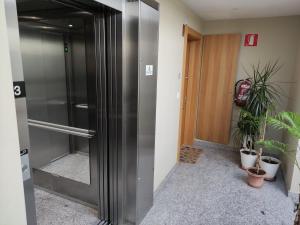 a stainless steel refrigerator in a hallway with plants at Pequeña habitación con vistas dentro de nuestra vivienda in Irún +27 photos
