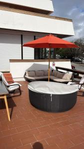 a hot tub with a red umbrella on a patio at Cascais Sun Terrace Casino Estoril Apartment in Estoril