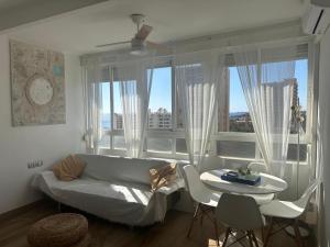 a living room with a couch and a table and windows at IRIVI 9 Apartment in Aguadulce