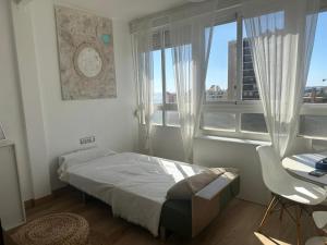 a bedroom with a bed and a desk and windows at IRIVI 9 Apartment in Aguadulce