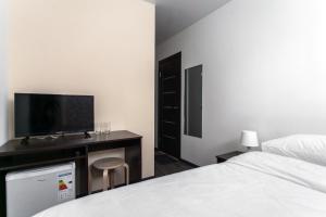 ニジニ・ノヴゴロドにあるHotel New Houseのベッドルーム(ベッド1台、薄型テレビ付)