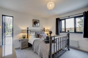 a bedroom with a bed and a window at The Old Stable by Winterton Cottages in Hemsby