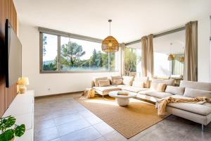 a living room with white furniture and large windows at Can Toni in Sa Pobla