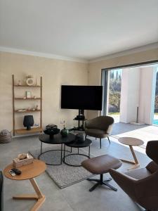a living room with a tv and a couch and chairs at Villa LagoBlu in Costermano sul Garda