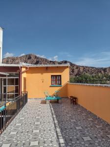 a patio of a house with a mountain in the background at La Colorada Hostal in Tilcara