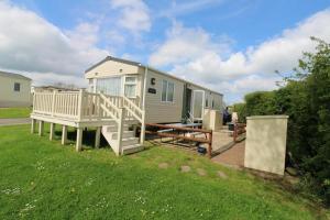 a tiny house with a porch and a deck at Country Retreat in Fenny Bentley