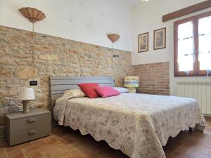 a bedroom with a bed and a brick wall at Appartamento Margarita Maris - 20mt dalla Spiaggia in Follonica