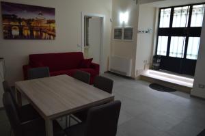 ローマにあるBea&Bのリビングルーム(テーブル、赤いソファ付)