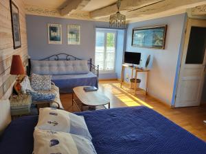 a living room with a bed and a couch at Clos St Ange (Dinan-St Malo) in Vildé-Guingalan