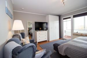 a bedroom with a bed and a tv and a bed and chairs at Atlantic 209 in Döse
