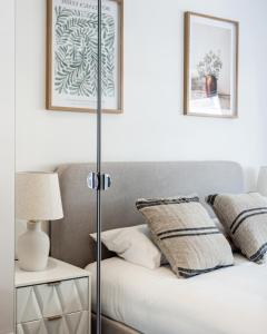 1 dormitorio con 1 cama con lámpara y 2 fotografías en Prime Central London Residences, en Londres
