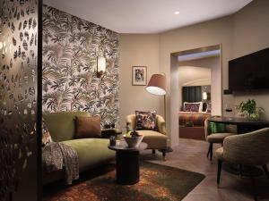 una sala de estar con un sofá y una cama en The Other House South Kensington, en Londres