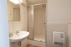 a bathroom with a sink and a shower at Hafenloft App 3 in Norderney