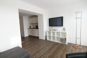 a living room with a flat screen tv on a wall at Hafenloft App 3 in Norderney