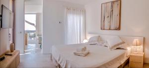 a white bedroom with a bed with towels on it at Apartamento Villa Cabrera in Colònia De Sant Jordi +11 photos