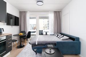 a bedroom with a bed and a blue couch at Rahulihomes City Centre Jyväskylä in Jyväskylä