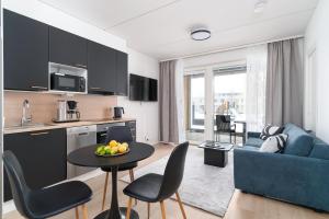 a kitchen and living room with a blue couch and a table at Rahulihomes City Centre Jyväskylä in Jyväskylä