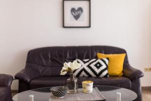 a living room with a couch and a table with flowers at Mayglück App 1 in Norderney