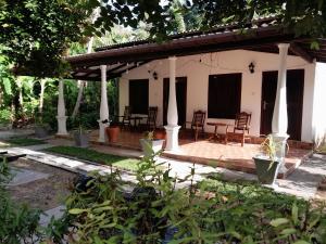 a patio of a house with chairs and a table at Banana Leaf Garden in Weligama
