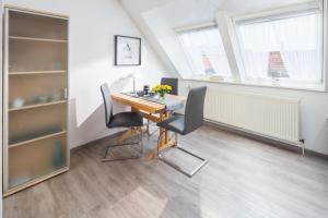 a dining room with a table and chairs at Mayglück App 3 in Norderney