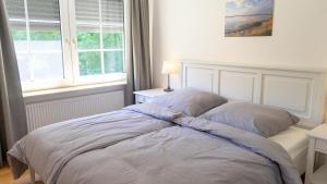 a bed sitting in a bedroom with a window at Dreschdiele - Landlust Osterwarf in Norddeich