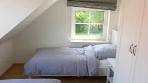 a bedroom with two beds and a window at Dreschdiele - Landlust Osterwarf in Norddeich