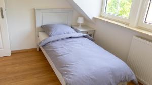 a small bedroom with a bed with a blue comforter at Dreschdiele - Landlust Osterwarf in Norddeich