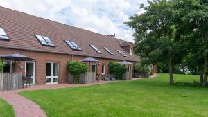 a brick house with a row of windows on it at Dreschdiele - Landlust Osterwarf in Norddeich