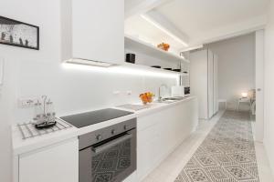 a white kitchen with white cabinets and a sink at Vatican White Domus in Rome