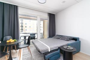 a bedroom with a bed and a table and chairs at Rahulihomes City Centre Jyväskylä in Jyväskylä