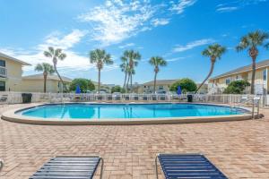 einen Pool mit Palmen in einem Resort in der Unterkunft Anchors Up-HeatedPool PrivBeach in Destin