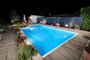 ein Swimmingpool in einem Garten bei Nacht in der Unterkunft Logis Hotel Restaurant Nougier in Saint-Étienne-de-Fursac