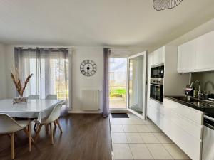 a kitchen and dining room with a table and a clock at Le Gregorien, Centre de Saint Gregoire in Saint-Grégoire +21 photos
