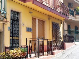 a yellow building with a gate and flowers on it at Donsanto Casa Vacanze in Taormina