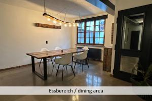 a dining room with a wooden table and chairs at KORN14 Loft - Parken, Küche in Freinsheim