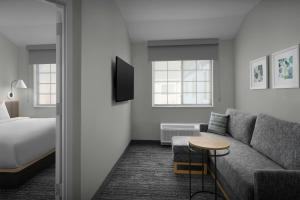 a hotel room with a bed and a couch and a table at TownePlace Suites by Marriott Annapolis in Annapolis