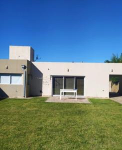 a white building with a bench in the yard at Casa de mar in Miramar