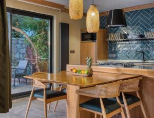 a kitchen with a wooden table and some chairs at Captivating Casa La Calypso in Kas