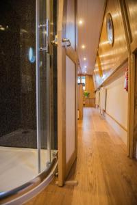 a hallway with a glass door and a wooden floor at Narrowboat Puzzle in Ely