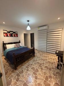 a bedroom with a bed with a blue comforter at Casa de campo con piscina, aire acondicionado, estacionamiento privado con BBQ in Barranquilla +21 photos