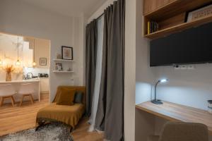een woonkamer met een televisie en een tafel met een stoel bij "The Loft" in Athens Heart 1 in Athene