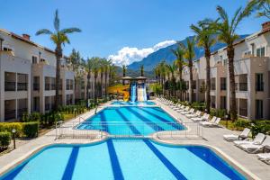 a pool at the resort with chairs and palm trees at Gravel Hotels Select - Ultra All Inclusive in Kemer
